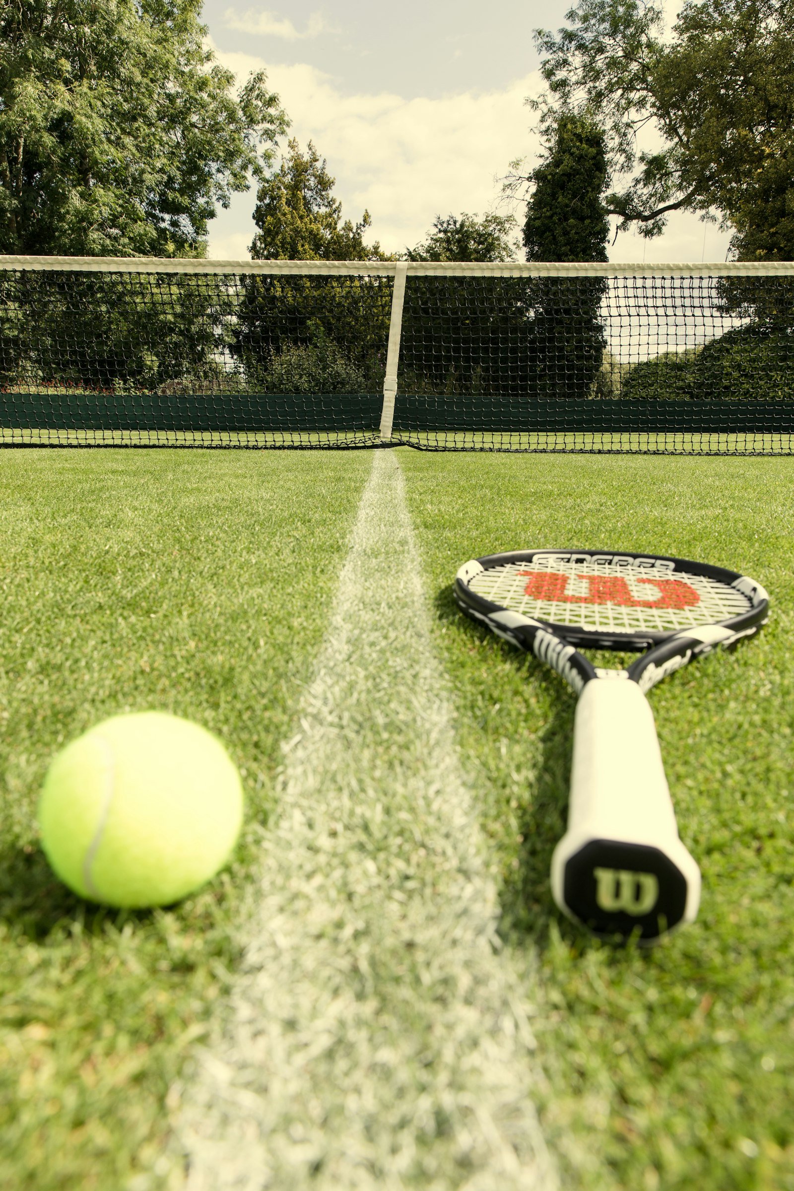 Tennis racket and ball on a grass court at Wimbledon